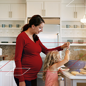 Kobieta w ciąży gotuje razem z córką. Wersja mobile