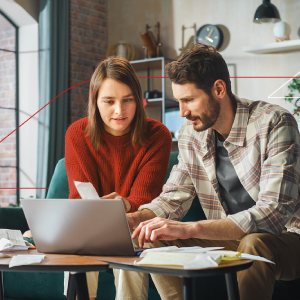 Para siedząca przy laptopie i planująca swoje wydatki. Wersja mobile.