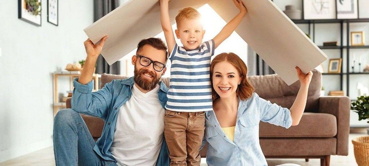 Rodzice z dzieckiem trzymają daszek nad głową, symbolizujący ochronę, jaką daje dobre ubezpieczenie NNW