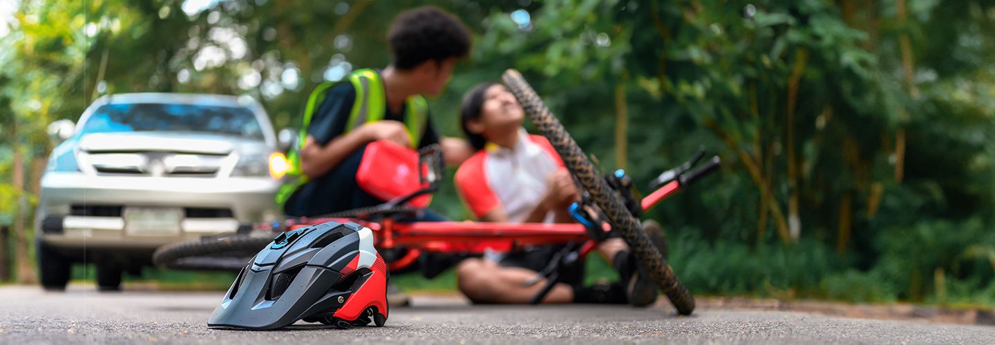 Osoba rozmawia z poszkodowanym rowerzystą - zdjęcie.