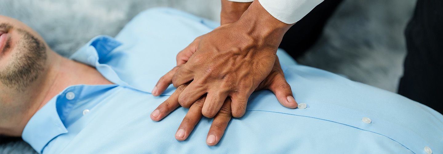 Osoba wykonuje pierwszą pomoc na mężczyźnie - zdjęcie.