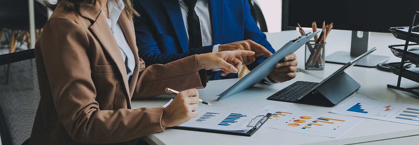 kobieta i mężczyzna konsultują dane na wykresach.