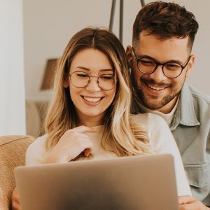Para korzystając z laptopa wspólnie przegląda oferty ubezpieczeń